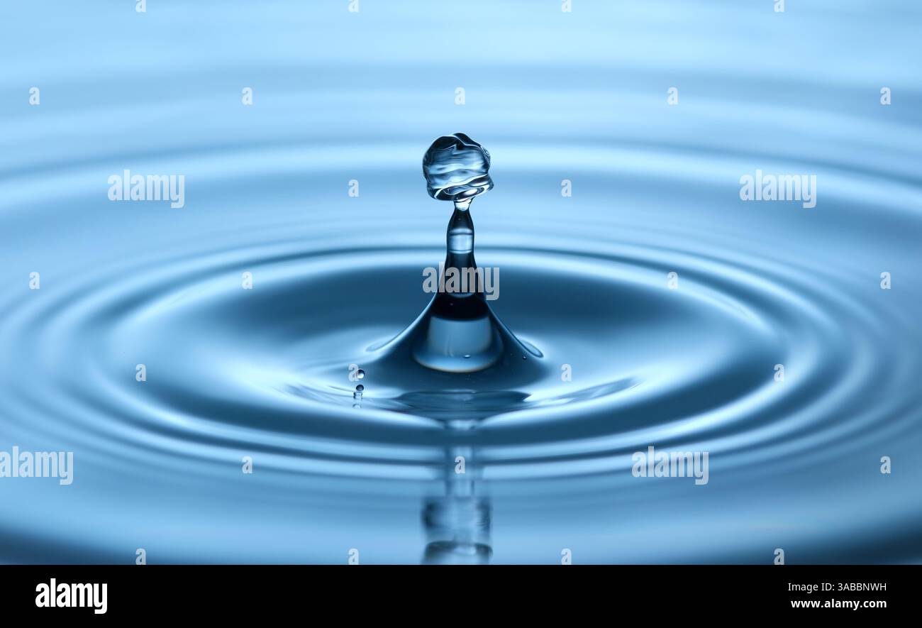 Gocce d'acqua con una forma ondulata nei dettagli, che crea increspature in blu e nitide riprese in studio Foto Stock