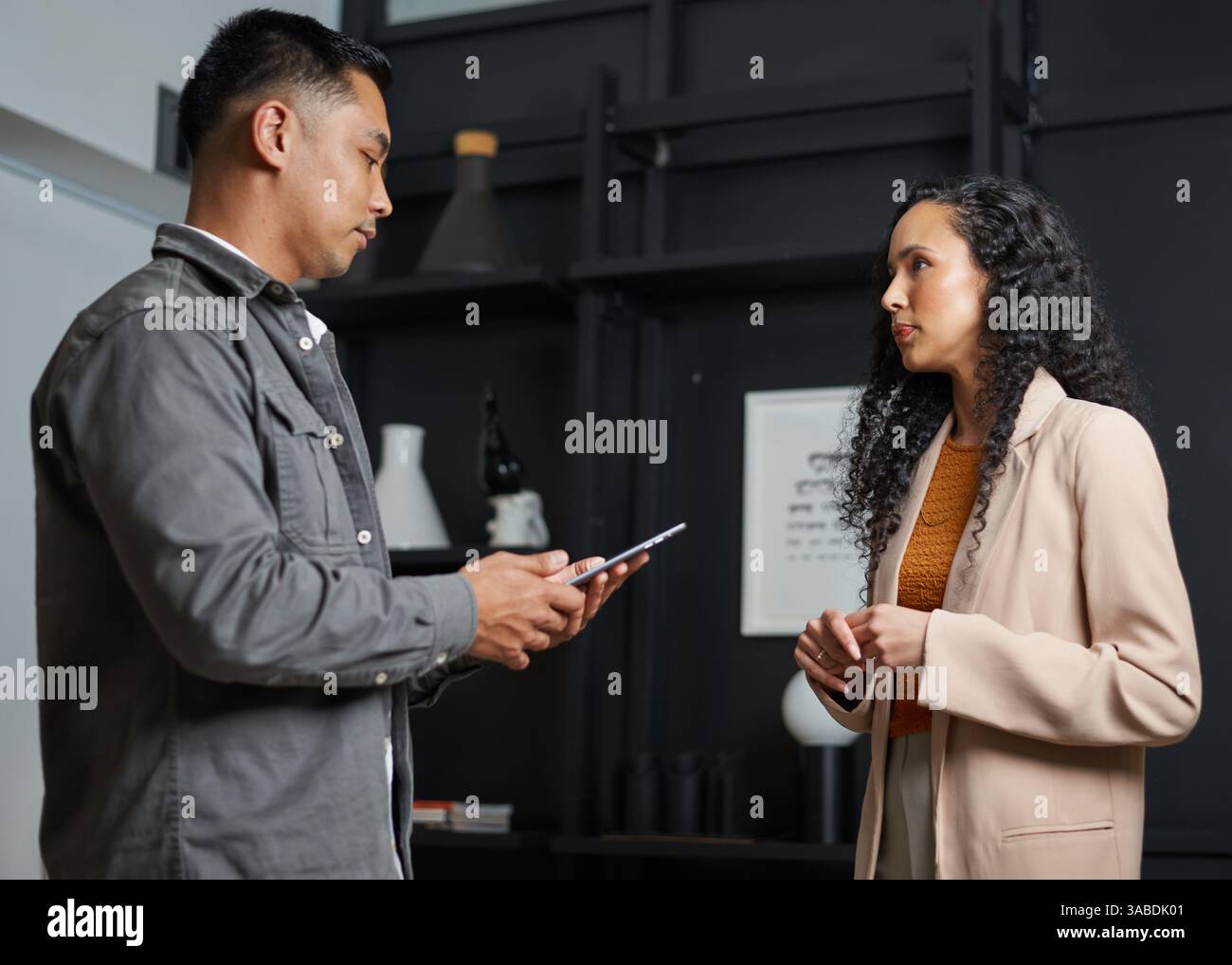 Due professionisti si sono impegnati in una conversazione sull'attività aziendale in un ambiente di ufficio Foto Stock