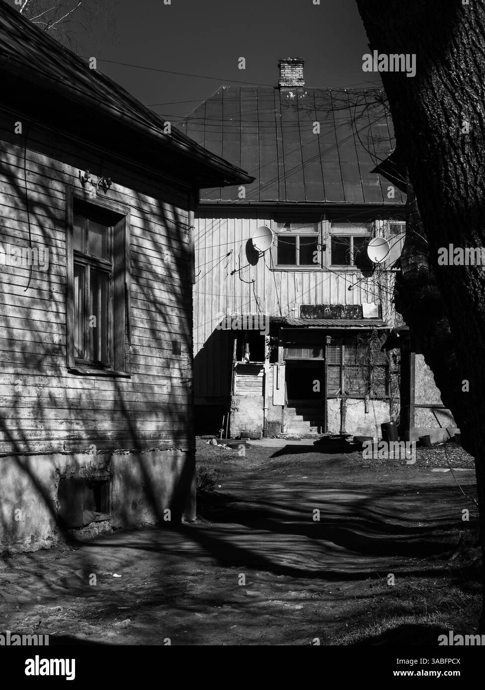 Vecchie case in legno in bianco e nero, raffiguranti il degrado urbano e la storia. Foto Stock