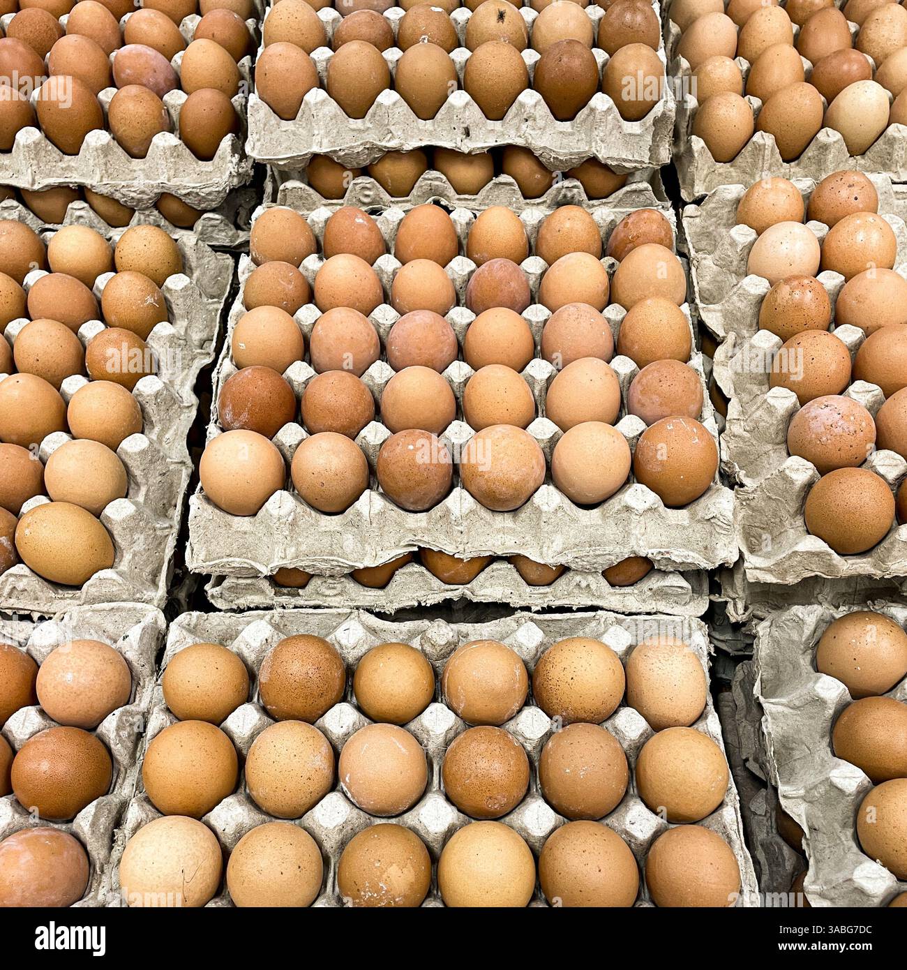 una pila di uova di pollo marrone esposta al mercato Foto Stock