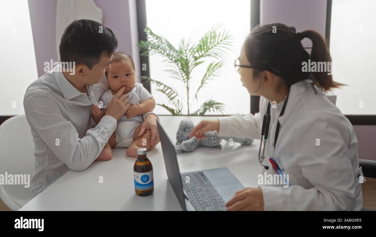 Il pediatra esamina il bambino con il padre nella stanza della clinica illustrando l'assistenza familiare e l'interazione medico-paziente in un ambiente accogliente. Foto Stock