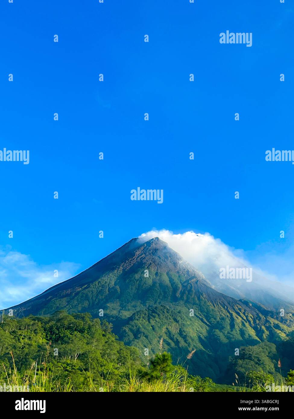 splendida vista del monte merapi contro il cielo blu e la nuvola bianca - Immagine stock catturata con smartphone