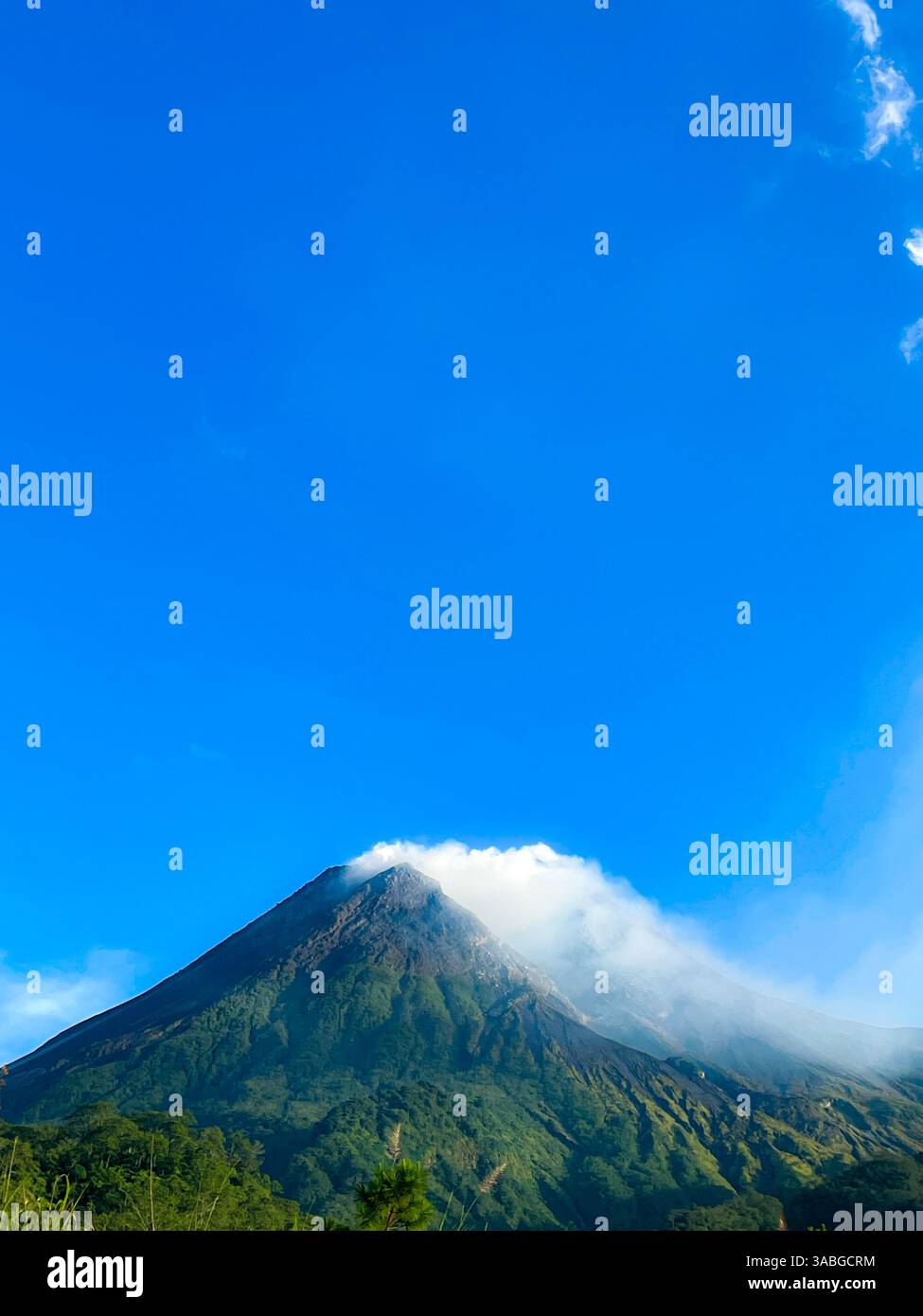 splendida vista del monte merapi contro il cielo blu e la nuvola bianca - Immagine stock catturata con smartphone