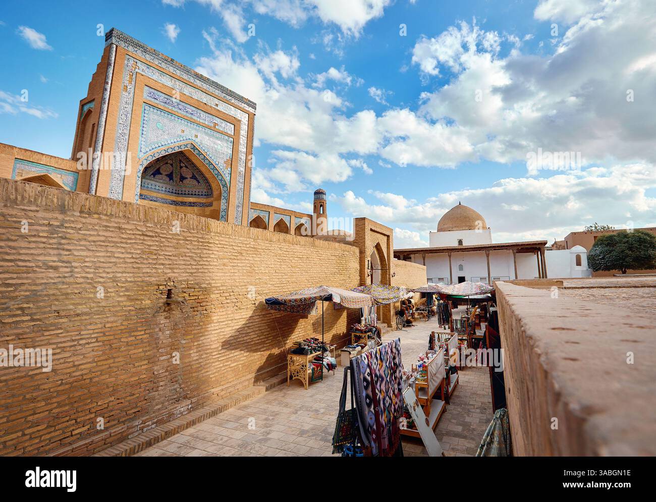 Tessuti etnici colorati, souvenir e sciarpa con ornamenti tradizionali dell'uzbekistan sul mercato di strada vicino alla vecchia madrasa di Khiva, Uzbekistan, Asia centrale Foto Stock