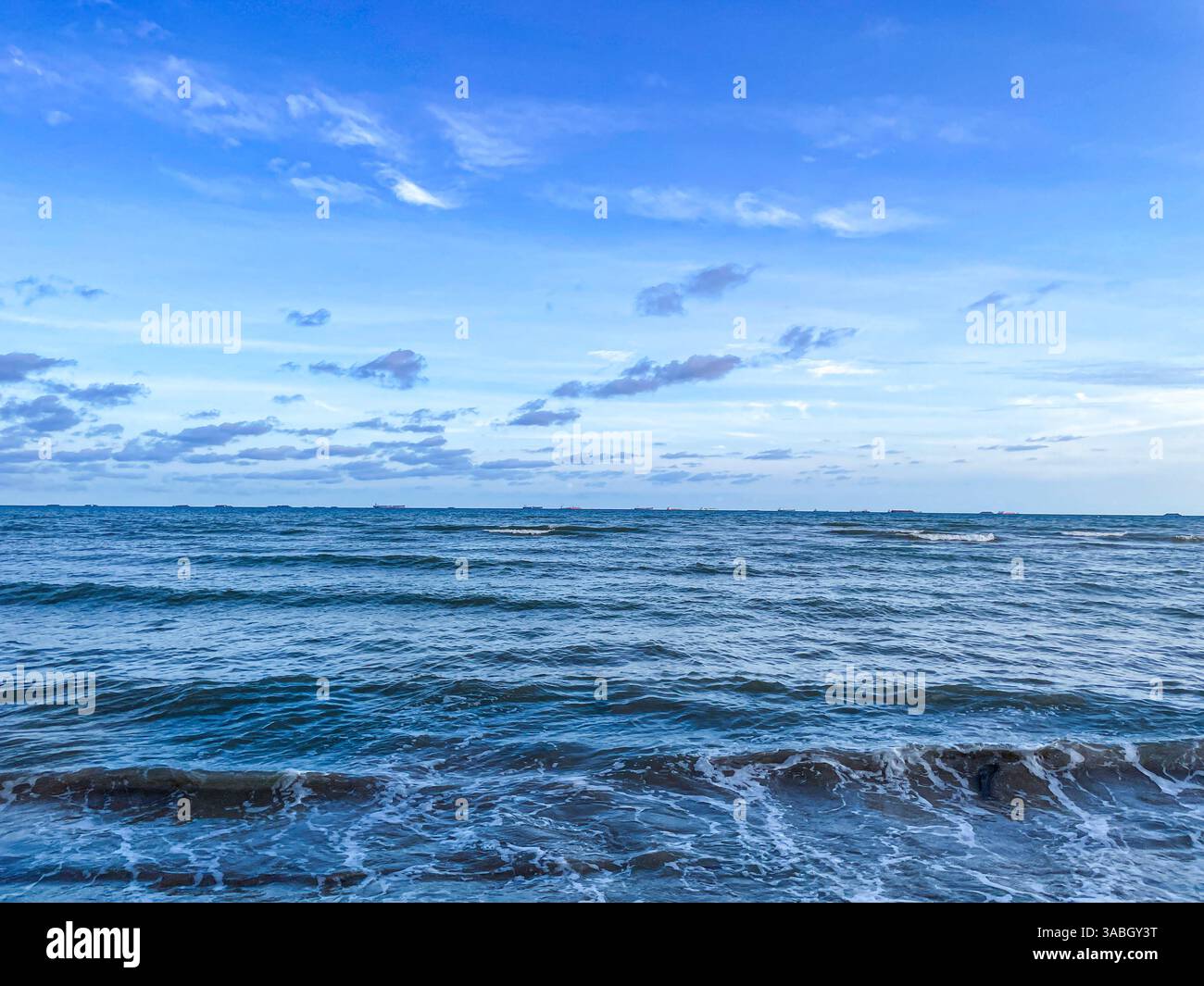 mare blu con onde e cielo blu perfetto Foto Stock