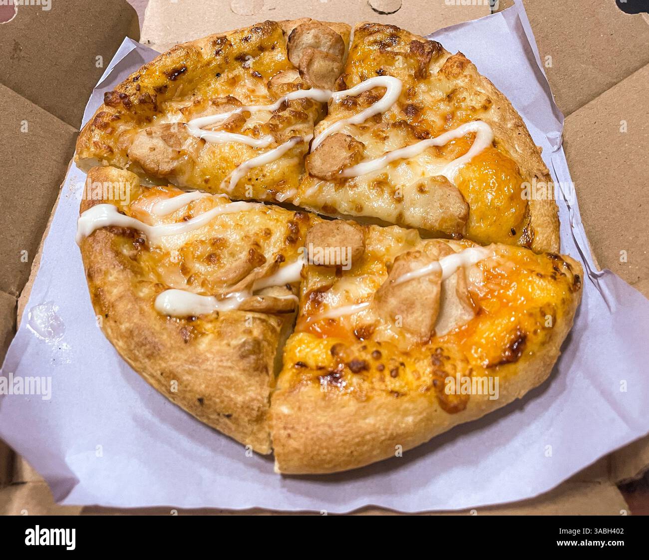 pizza al pollo con mozzarella tagliata in 4 pezzi in una scatola di cartone - Immagine stock catturata con smartphone