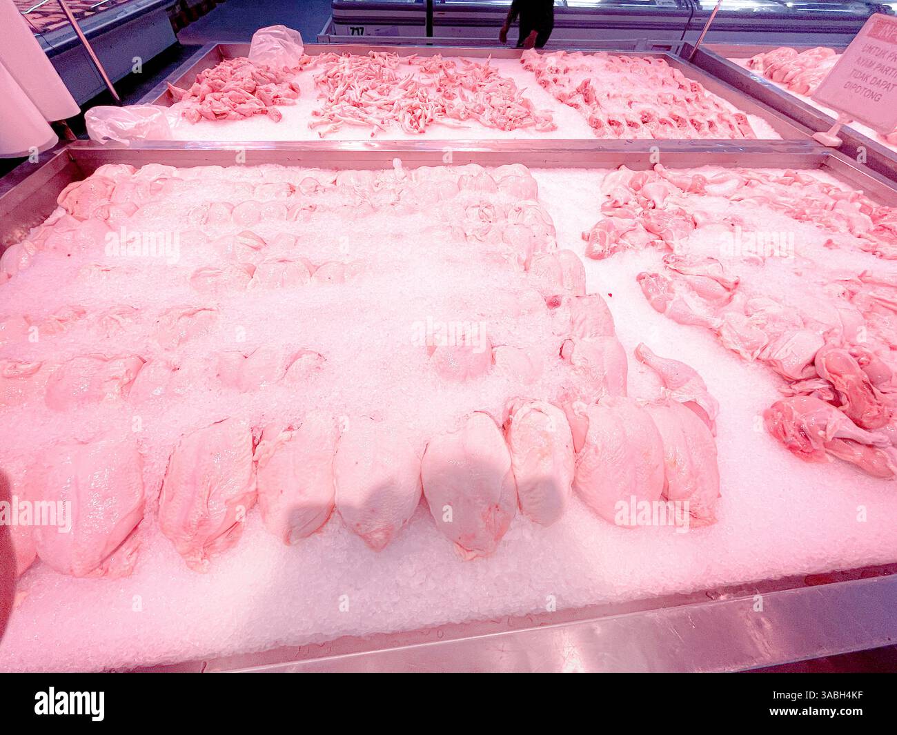 Polli interi freschi, congelati, ricoperti di ghiaccio nella sezione «carne di mercato» - Immagine stock catturata con smartphone