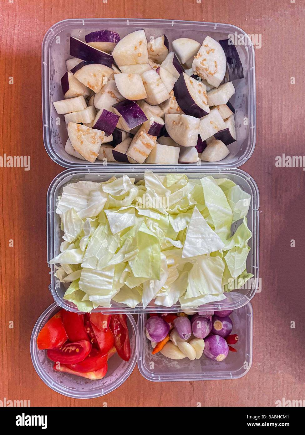 vista dall'alto delle verdure fresche tagliate in un contenitore contenente cavolo, cipolle di melanzane e pomodori - Immagine stock catturata con smartphone
