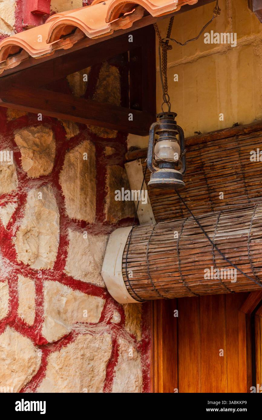Lanterna rustica appesa all'esterno di un edificio in pietra e legno Foto Stock