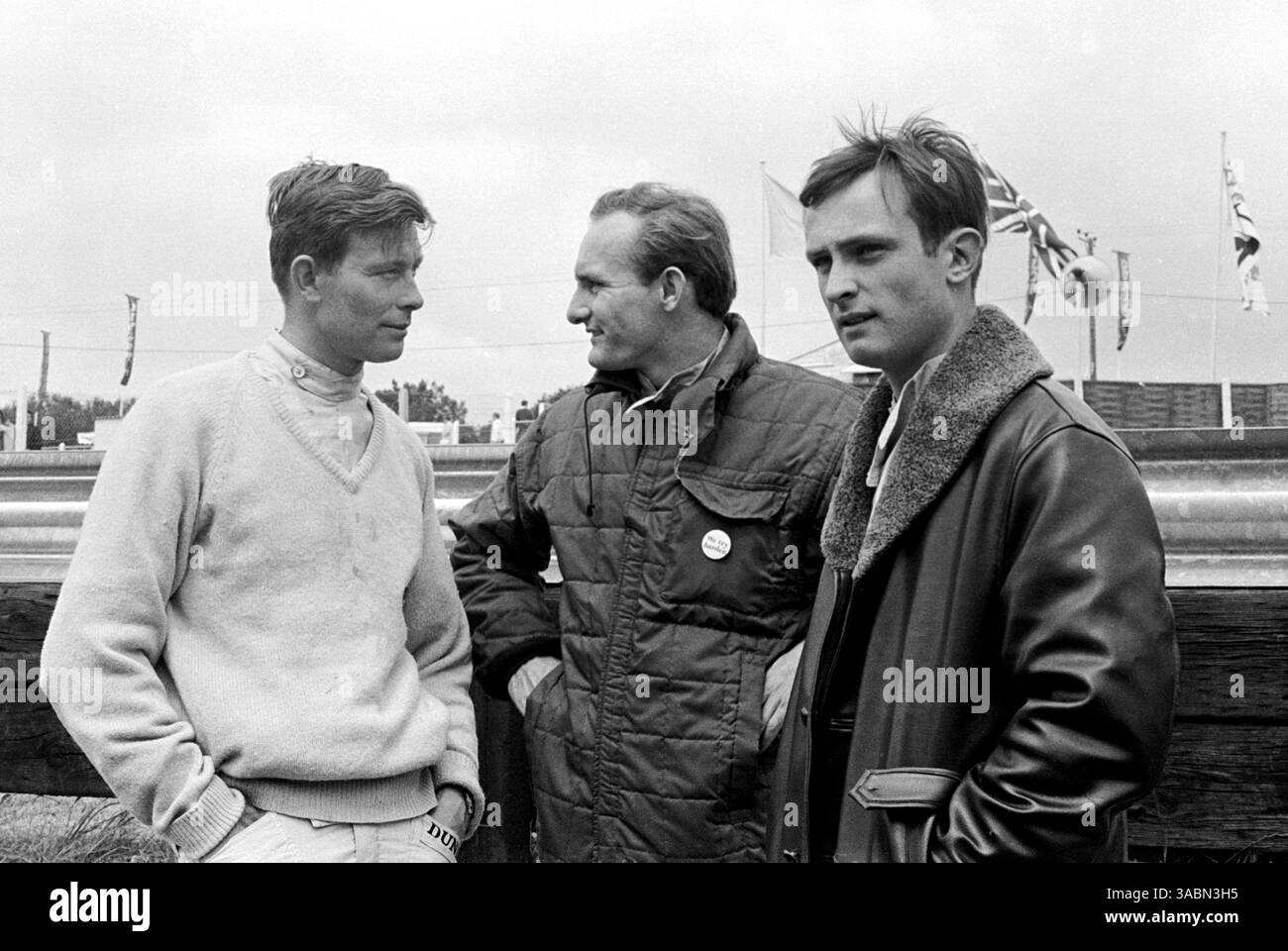 I compagni del team Lotus parlano nella pit Lane (da L a R): Mike Spence (GBR), Mike Hailwood (GBR) Lotus e Chris Amon (NZL)...Gran Premio di Gran Bretagna, Brands Hatch, 11 luglio 1964. (Immagine di credito: ©Sutton Motorsports/ZUMA Press) Foto Stock