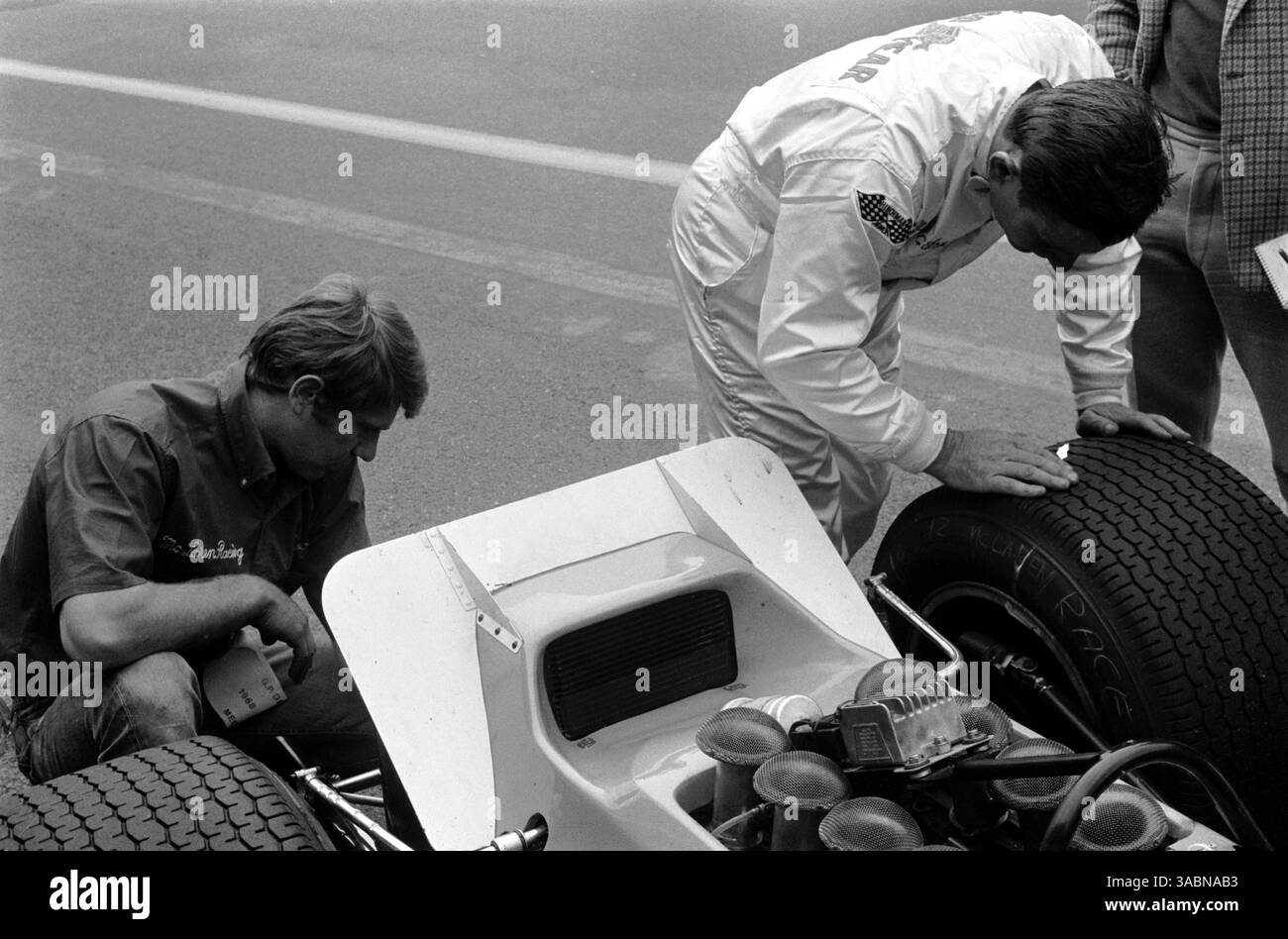 Gli Aerofoils sono stati collegati alle vetture di F1 per la prima volta. Ecco un piccolo profilo aerodinamico attaccato al motore della McLaren M7A del vincitore della gara Bruce McLaren (NZL) con Tyler Alexander (a sinistra) che esamina la parte posteriore della vettura. Gran Premio del Belgio, Spa-Francorchamps, 9 giugno 1968. (Immagine di credito: ©Sutton Motorsports/ZUMA Press) Foto Stock