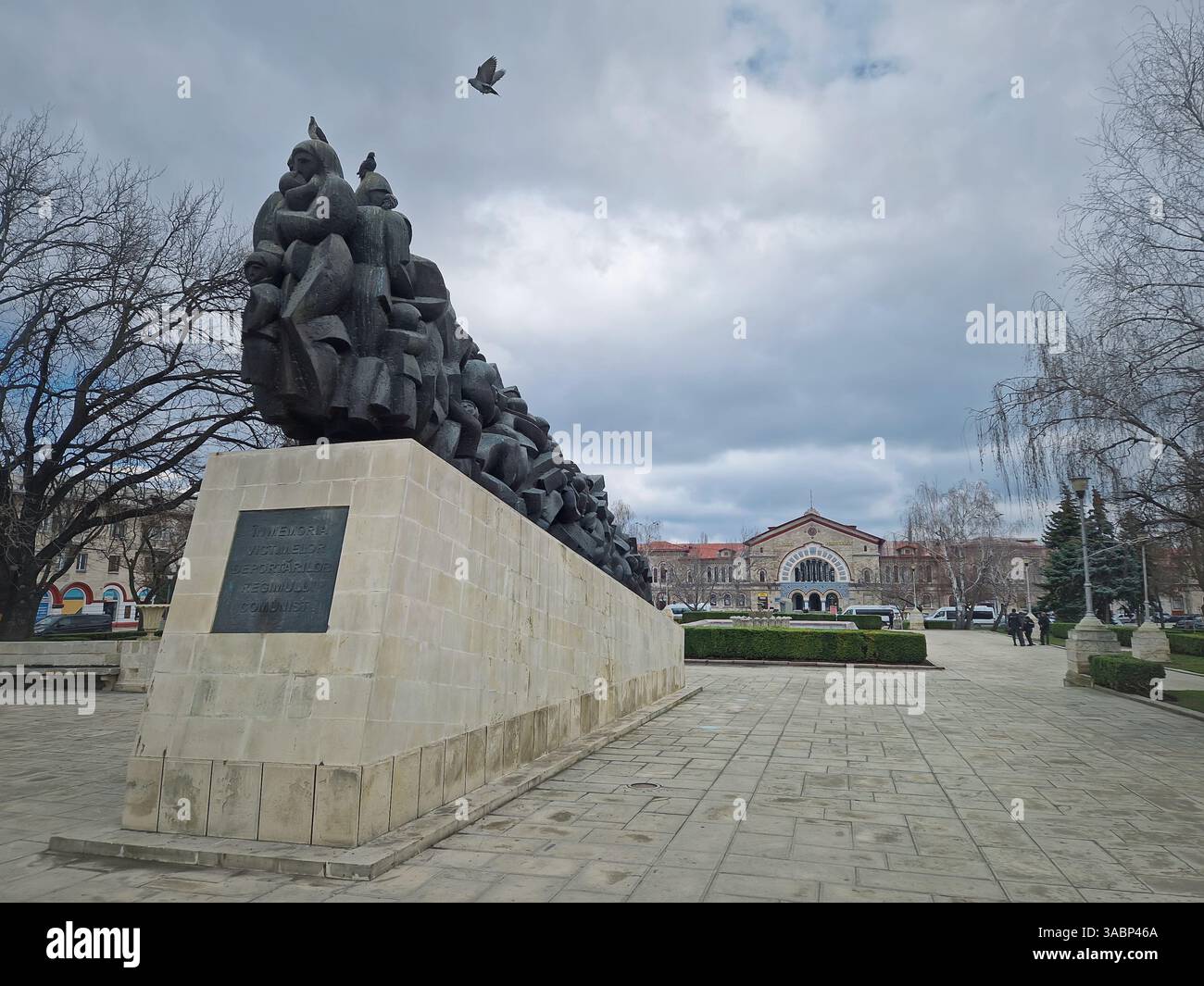 CHISINAU, MOLDAVIA - 20 marzo 2024 Monumento in memoria delle vittime della deportazione del regime comunista accanto all'edificio della stazione ferroviaria - Immagine stock catturata con smartphone