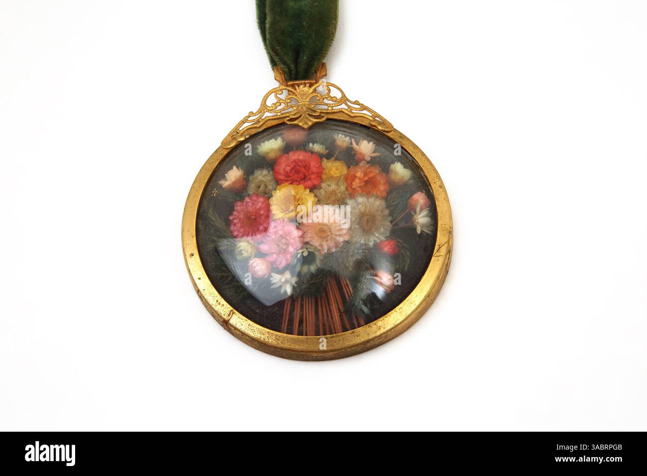 Ciondolo in vetro convesso in stile vittoriano vintage con fiori secchi all'interno Foto Stock