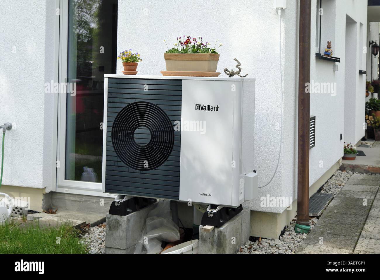 Unità esterna di una pompa di calore a sorgente d'aria Vaillant sulla parete di una casa indipendente Foto Stock