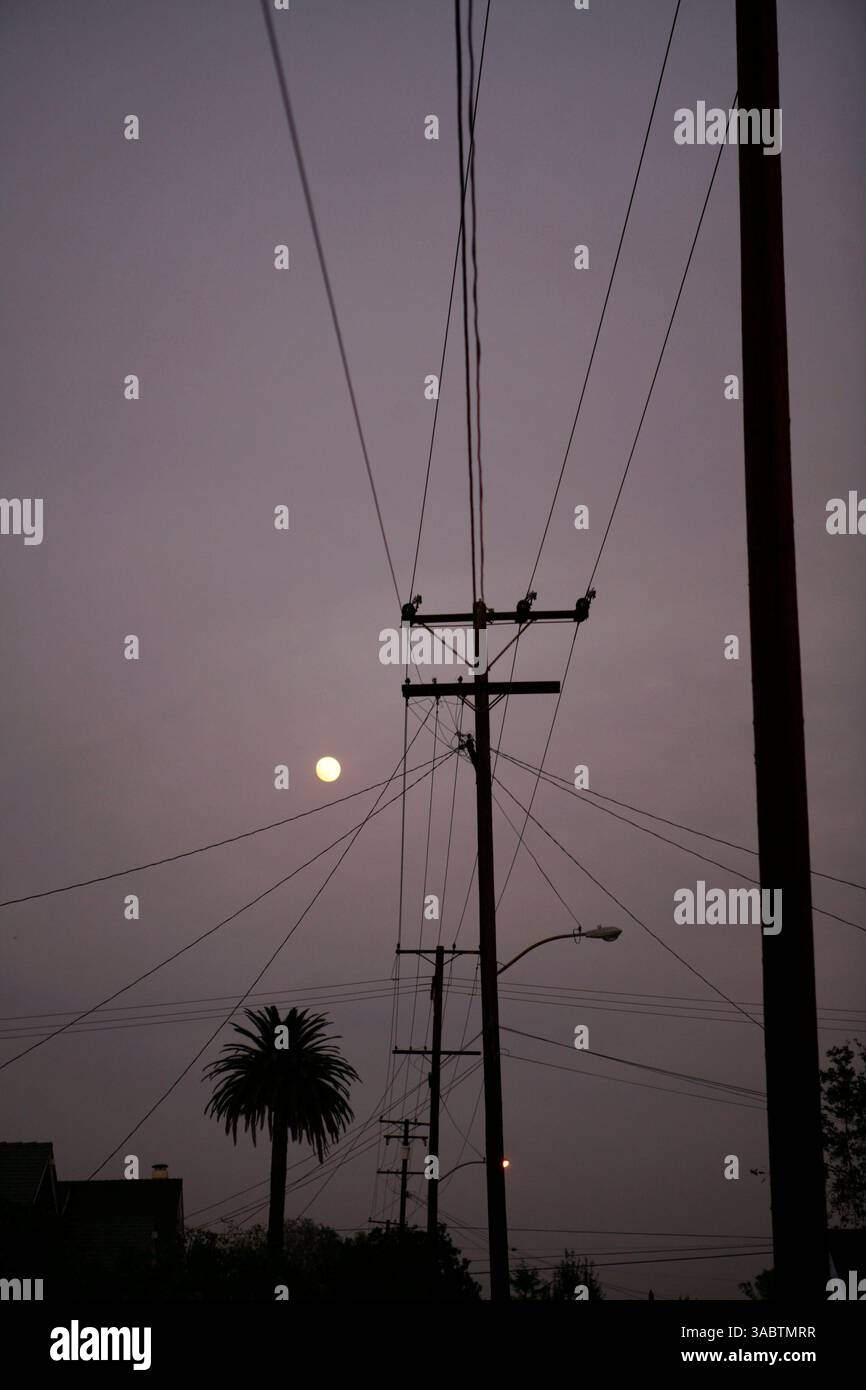 25 ottobre 2007 - Orange, CALIFORNIA, Stati Uniti - i cieli della contea di Orange sono coperti di fumo mentre i vigili del fuoco in tutta la California meridionale combattono le fiamme. Il più vicino, il Santiago Fire, a pochi chilometri di distanza, è contenuto al 30% secondo il California Department of Forestry and Fire Protection. I funzionari confermano giovedì mattina che l'incendio di Santiago è stato intenzionalmente avviato da un piromane in due posti lungo una stradina poco trafficata. NELLA FOTO: Poco prima del tramonto, il fumo si libra sulle linee telefoniche dopo che i venti sono scesi il 24 ottobre 2007. (Immagine di credito: © Jacqueline Lovato/ Foto Stock