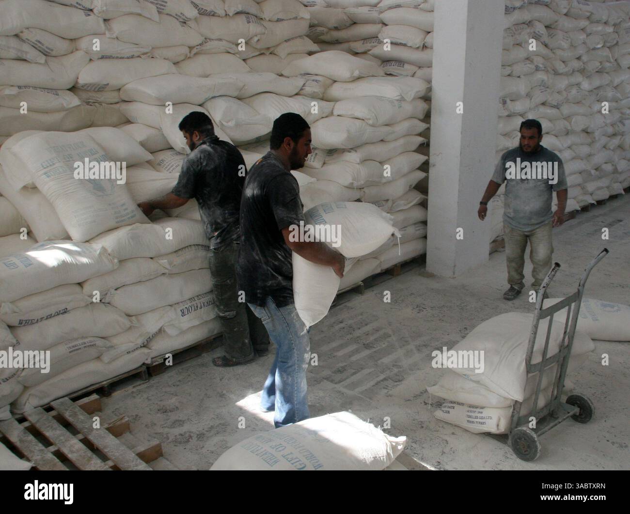 30 ottobre 2007 - Gaza City, Striscia di Gaza - i palestinesi ricevono aiuti in un magazzino dell'UNRWA che distribuisce cibo nel campo profughi Shatee a Gaza City, 30 ottobre 2007. I gruppi per i diritti umani hanno contestato la riduzione delle forniture di carburante a Gaza da parte di Israele e la sua intenzione di ridurre l'elettricità, e i palestinesi hanno avvertito che le misure potrebbero portare a una crisi umanitaria. (Immagine di credito: © Fady Adwan/ZUMA Press) Foto Stock