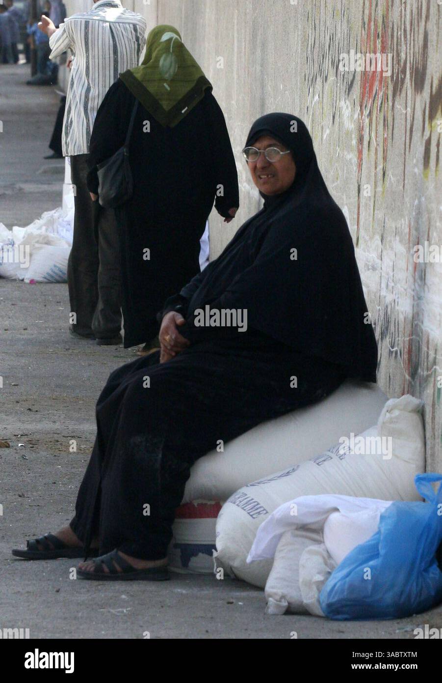 30 ottobre 2007 - Gaza City, Striscia di Gaza - Una donna palestinese dopo aver ricevuto aiuti in un magazzino dell'UNRWA che distribuiva cibo nel campo profughi Shatee a Gaza City, 30 ottobre 2007. I gruppi per i diritti umani hanno contestato la riduzione delle forniture di carburante a Gaza da parte di Israele e la sua intenzione di ridurre l'elettricità, e i palestinesi hanno avvertito che le misure potrebbero portare a una crisi umanitaria. (Immagine di credito: © Fady Adwan/ZUMA Press) Foto Stock