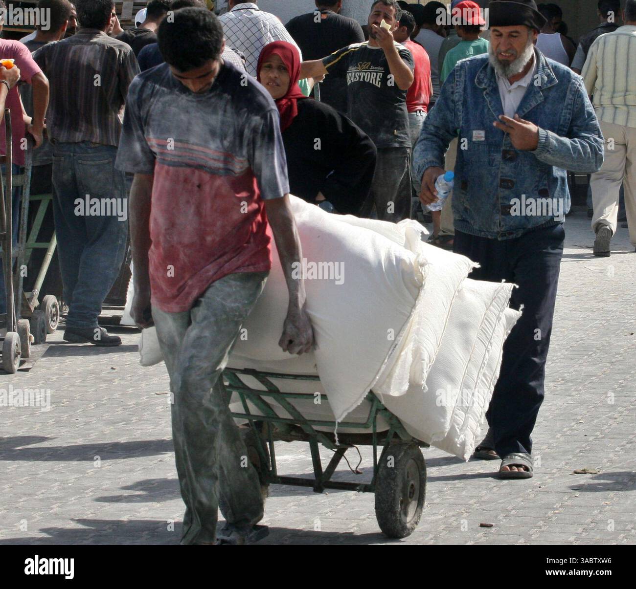 30 ottobre 2007 - Gaza City, Striscia di Gaza - i palestinesi ricevono aiuti in un magazzino dell'UNRWA che distribuisce cibo nel campo profughi Shatee a Gaza City, 30 ottobre 2007. I gruppi per i diritti umani hanno contestato la riduzione delle forniture di carburante a Gaza da parte di Israele e la sua intenzione di ridurre l'elettricità, e i palestinesi hanno avvertito che le misure potrebbero portare a una crisi umanitaria. (Immagine di credito: © Fady Adwan/ZUMA Press) Foto Stock