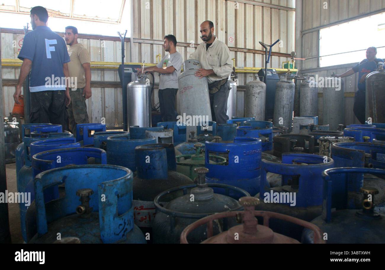 30 ottobre 2007 - Gaza City, Striscia di Gaza - i lavoratori palestinesi riempiono le bombole di gas in un deposito nella città di Gaza lunedì 30 ottobre 2007. I gruppi per i diritti umani hanno contestato la riduzione delle forniture di carburante a Gaza da parte di Israele e la sua intenzione di ridurre l'elettricità, e i palestinesi hanno avvertito che le misure potrebbero portare a una crisi umanitaria. (Immagine di credito: © Fady Adwan/ZUMA Press) Foto Stock