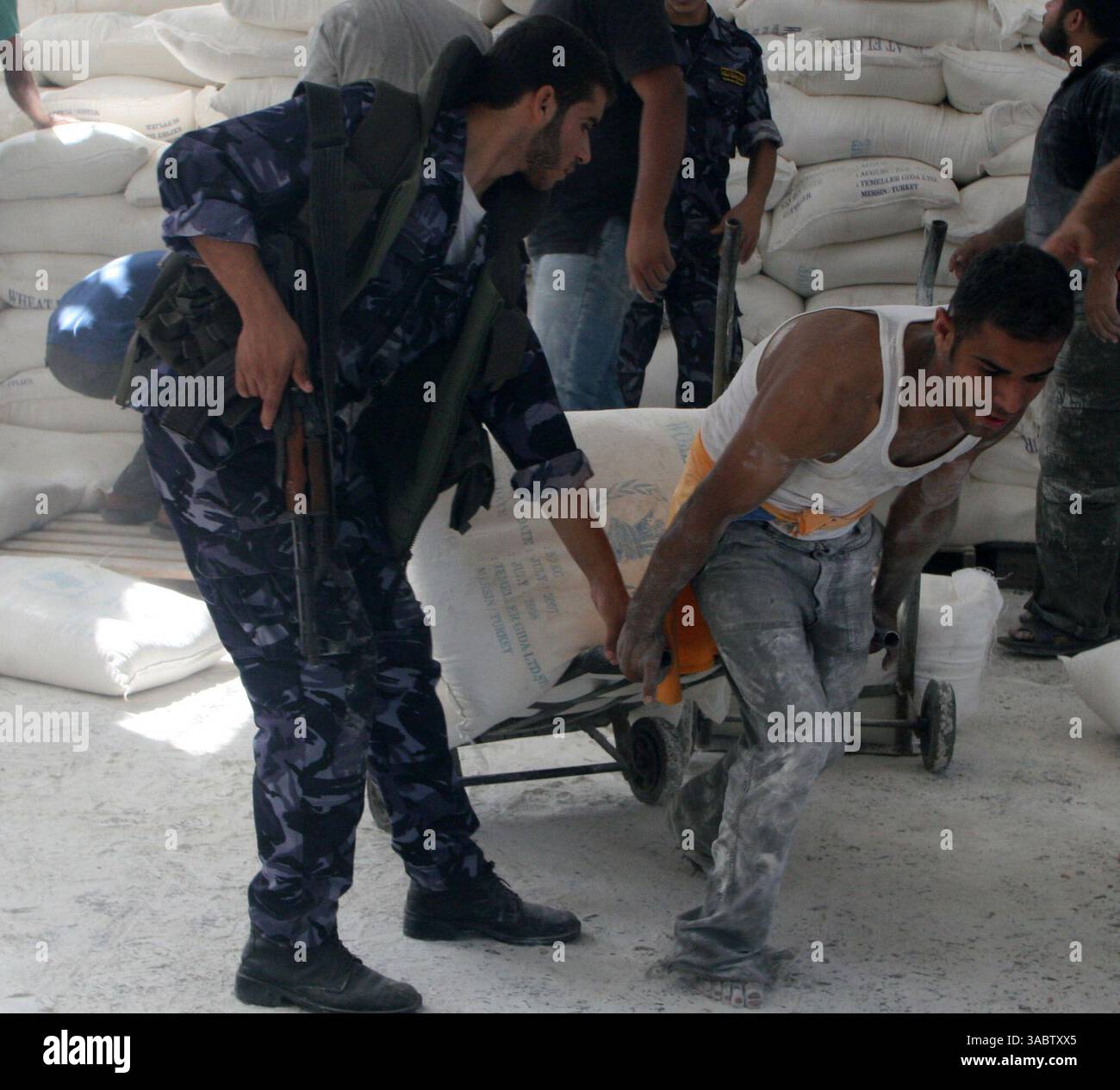 30 ottobre 2007 - Gaza City, Striscia di Gaza - Un palestinese riceve aiuti in un magazzino dell'UNRWA che distribuisce cibo nel campo profughi Shatee a Gaza City, 30 ottobre 2007. I gruppi per i diritti umani hanno contestato la riduzione delle forniture di carburante a Gaza da parte di Israele e la sua intenzione di ridurre l'elettricità, e i palestinesi hanno avvertito che le misure potrebbero portare a una crisi umanitaria. (Immagine di credito: © Fady Adwan/ZUMA Press) Foto Stock