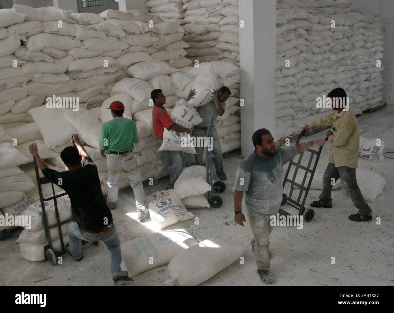 30 ottobre 2007 - Gaza City, Striscia di Gaza - i palestinesi ricevono aiuti in un magazzino dell'UNRWA che distribuisce cibo nel campo profughi Shatee a Gaza City, 30 ottobre 2007. I gruppi per i diritti umani hanno contestato la riduzione delle forniture di carburante a Gaza da parte di Israele e la sua intenzione di ridurre l'elettricità, e i palestinesi hanno avvertito che le misure potrebbero portare a una crisi umanitaria. (Immagine di credito: © Fady Adwan/ZUMA Press) Foto Stock