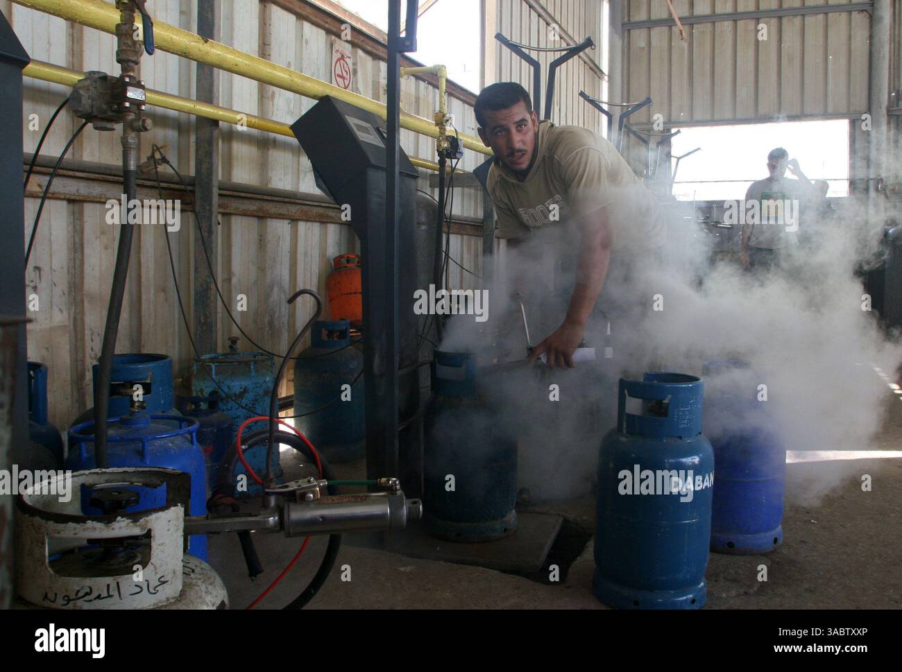 30 ottobre 2007 - Gaza City, Striscia di Gaza - i lavoratori palestinesi riempiono le bombole di gas in un deposito nella città di Gaza lunedì 30 ottobre 2007. I gruppi per i diritti umani hanno contestato la riduzione delle forniture di carburante a Gaza da parte di Israele e la sua intenzione di ridurre l'elettricità, e i palestinesi hanno avvertito che le misure potrebbero portare a una crisi umanitaria. (Immagine di credito: © Fady Adwan/ZUMA Press) Foto Stock