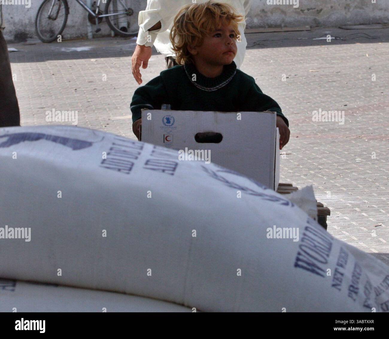 30 ottobre 2007 - Gaza City, Striscia di Gaza - Un ragazzo palestinese in un magazzino dell'UNRWA che distribuisce cibo nel campo profughi Shatee a Gaza City, 30 ottobre 2007. I gruppi per i diritti umani hanno contestato la riduzione delle forniture di carburante a Gaza da parte di Israele e la sua intenzione di ridurre l'elettricità, e i palestinesi hanno avvertito che le misure potrebbero portare a una crisi umanitaria. (Immagine di credito: © Fady Adwan/ZUMA Press) Foto Stock