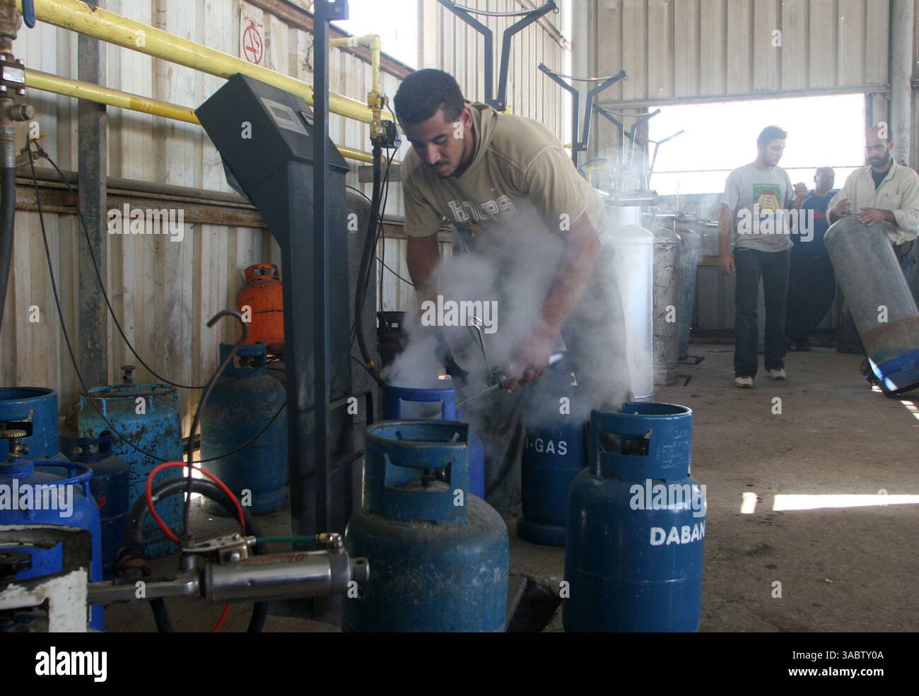 30 ottobre 2007 - Gaza City, Striscia di Gaza - i lavoratori palestinesi riempiono le bombole di gas in un deposito nella città di Gaza lunedì 30 ottobre 2007. I gruppi per i diritti umani hanno contestato la riduzione delle forniture di carburante a Gaza da parte di Israele e la sua intenzione di ridurre l'elettricità, e i palestinesi hanno avvertito che le misure potrebbero portare a una crisi umanitaria. (Immagine di credito: © Fady Adwan/ZUMA Press) Foto Stock