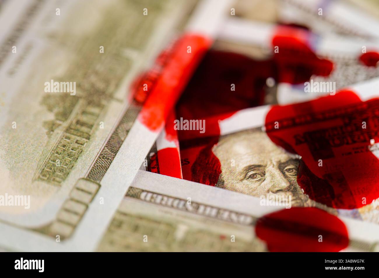 Macchie di sangue su Dollar Bills. Sanguinosa finanza criminale. Gocce di sangue cadono sui dollari. La faccia di Benjamin Franklins sul disegno di legge e' nel sangue. Il sangue scorre lentamente Foto Stock