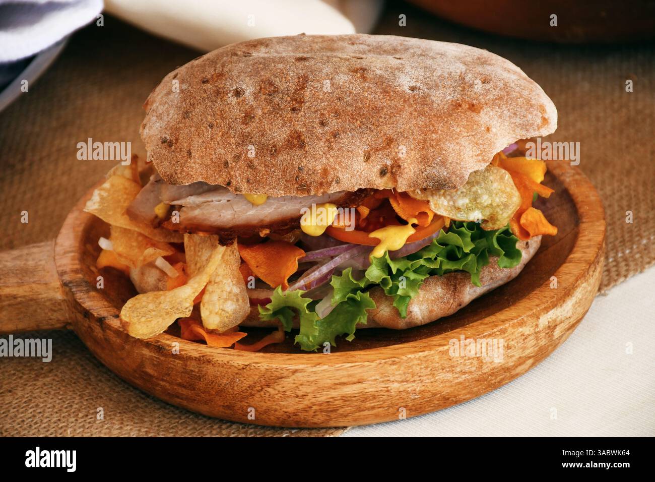 Pan chapla con chicharrón, una colazione tradizionale da Ayacucho, Perù. Pane andino croccante servito con maiale fritto e salsa creola. Foto Stock