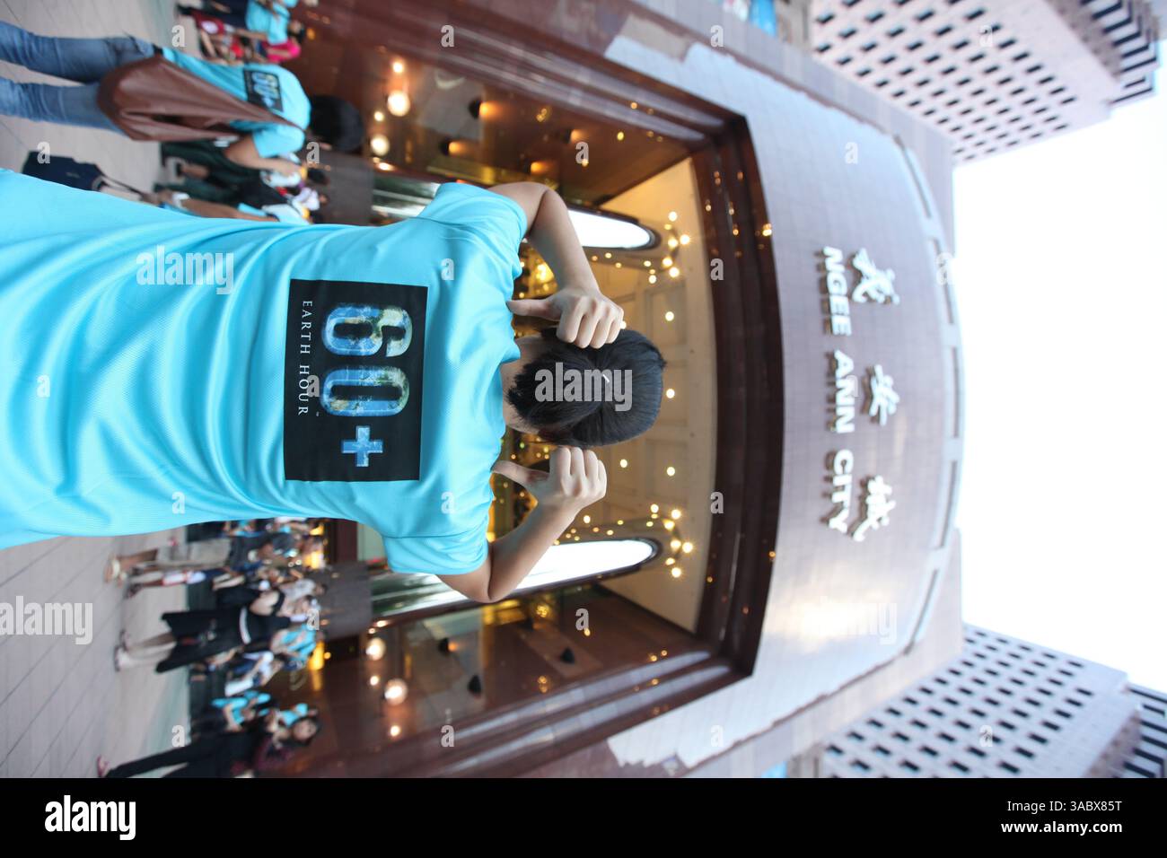 La visione verticale, il punto persona sul retro del tee per sostenere l'evento Earth Hour, riguarda la solidarietà, la speranza, il potere dell'azione globale collettiva, Singapore. Foto Stock