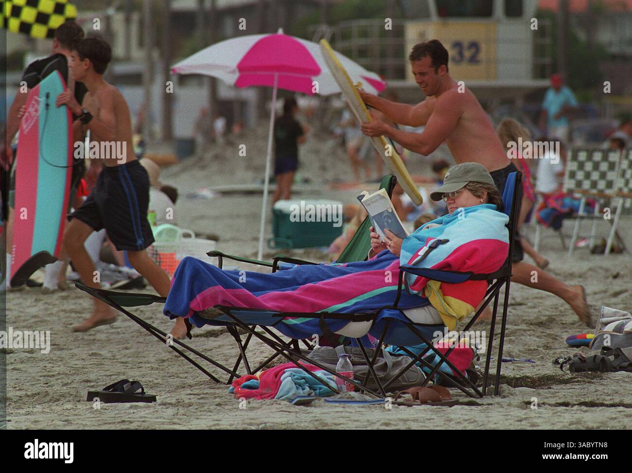 (Pubblicato il 07/06/2003, Bulldog Edition, B-3): Bundled Up Against the Foggy Afternoon Air, Sally Butler of Tempe, Arizona, è determinata ad avere l'ultimo giorno della sua settimana di vacanza qui sulla spiaggia. Non preoccuparti, ha detto, era più soleggiato all'inizio della settimana, e ha delle vere scottature sotto tutti quegli asciugamani. foto di peggy peattie Foto Stock