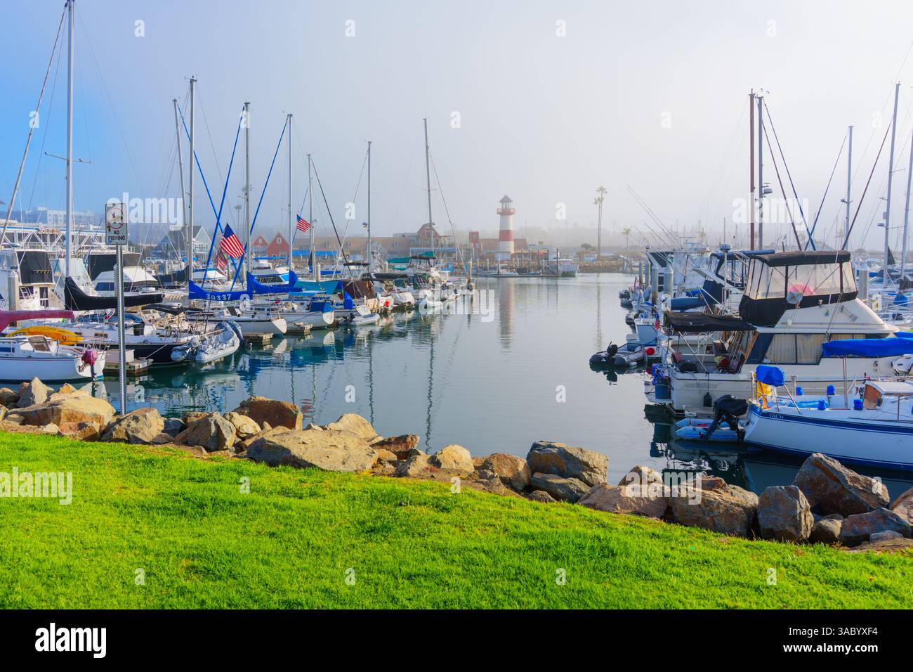 Oceanside, California - 3 gennaio 2025: Tranquilla marina di Oceanside, California, con barche a vela e un faro in condizioni nebbiose, Foto Stock