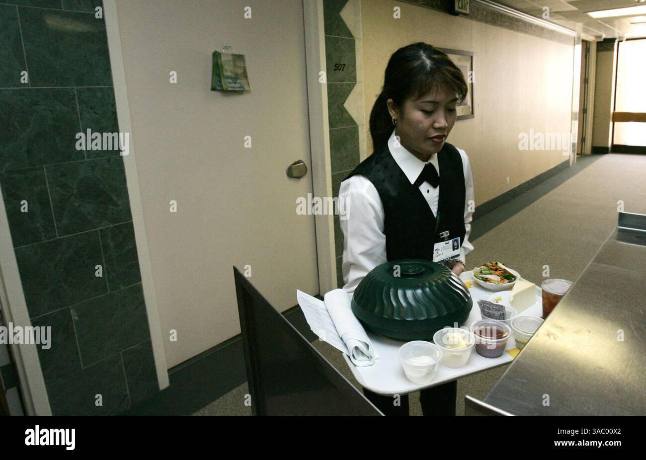 (PUBBLICATO il 16/04/2005, NC-1, NI-1 ) Agnes Brown, un assistente del servizio in camera, si prepara a servire un pasto in una stanza del reparto maternità dell'ospedale Pomerado di Poway il giovedì. Questo fa parte di un programma di portineria presso l'ospedale dove i pazienti possono ordinare il servizio in camera come in un hotel. Foto UT di Eduardo Contreras Foto Stock