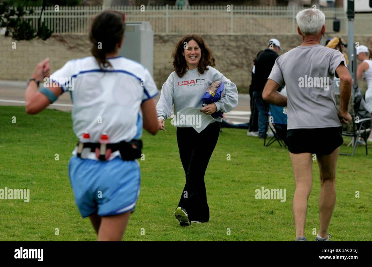 (Pubblicato il 1/5/2005, NC-4) l'allenatore degli USA Fit Katie Johnson, di Jamul, centro, sorride all'allenamento dei corridori per la Carlsbad Marathon e la Marathon del 1/2, mentre corrono da lei a Cannon Road e Carlsbad Boulevard.--Laura Embry/Union-Tribune Foto Stock