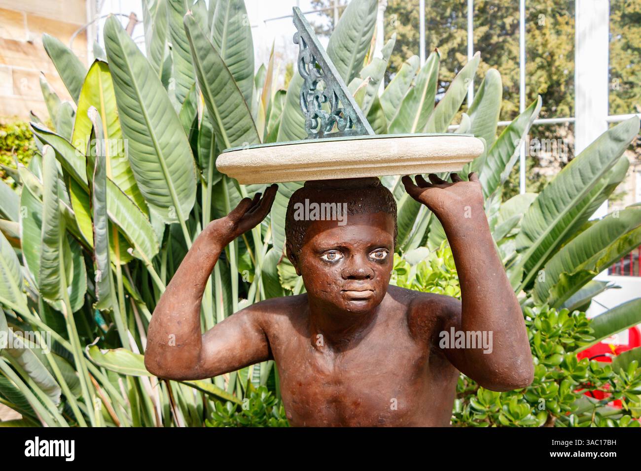 Controverso meridiana del cast georgiano principale dello schiavo nero inginocchiato il Blackamoor, nella serra di vetro vittoriana Wentworth Castle barnsley yorkshire Foto Stock