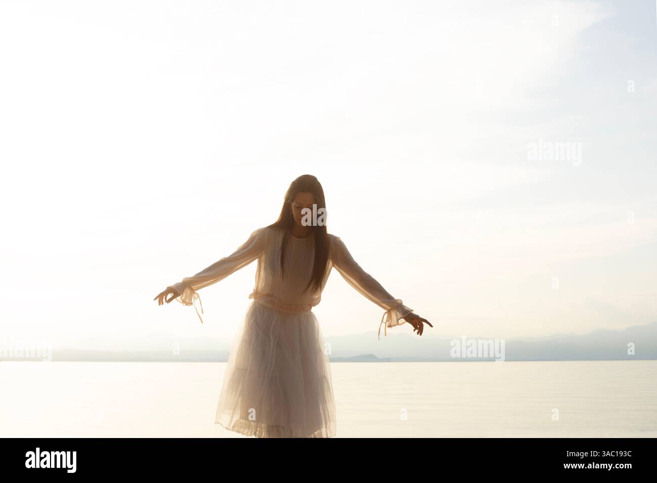 donna avventurosa che cammina in equilibrio di fronte al mare, concetto di equilibrio e libertà Foto Stock