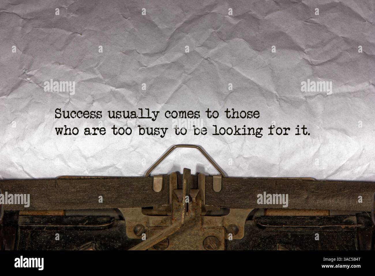 Il successo di solito arriva a coloro che sono troppo impegnati per cercarla da vicino di una frase digitata e centrata su un foglio di carta su una vecchia vinta Foto Stock