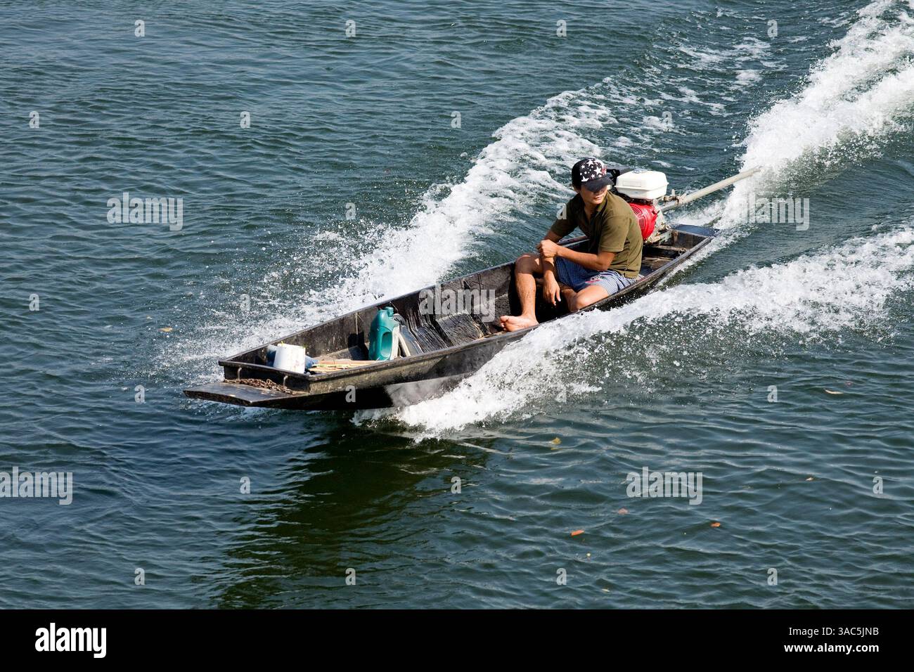 20 febbraio 2008 - Kanchanaburi, Thailandia - Un uomo tailandese usa una "barca a coda lunga" per attraversare il fiume Kwai a Kanchanaburi, Thailandia. Le barche a coda lunga sono comuni sui corsi d'acqua thailandesi, le barche sono molto veloci con un pescaggio poco profondo, il che le rende molto manovrabili sui fiumi e sui canali. (Immagine di credito: © Jack Kurtz/ZUMA Press) Foto Stock