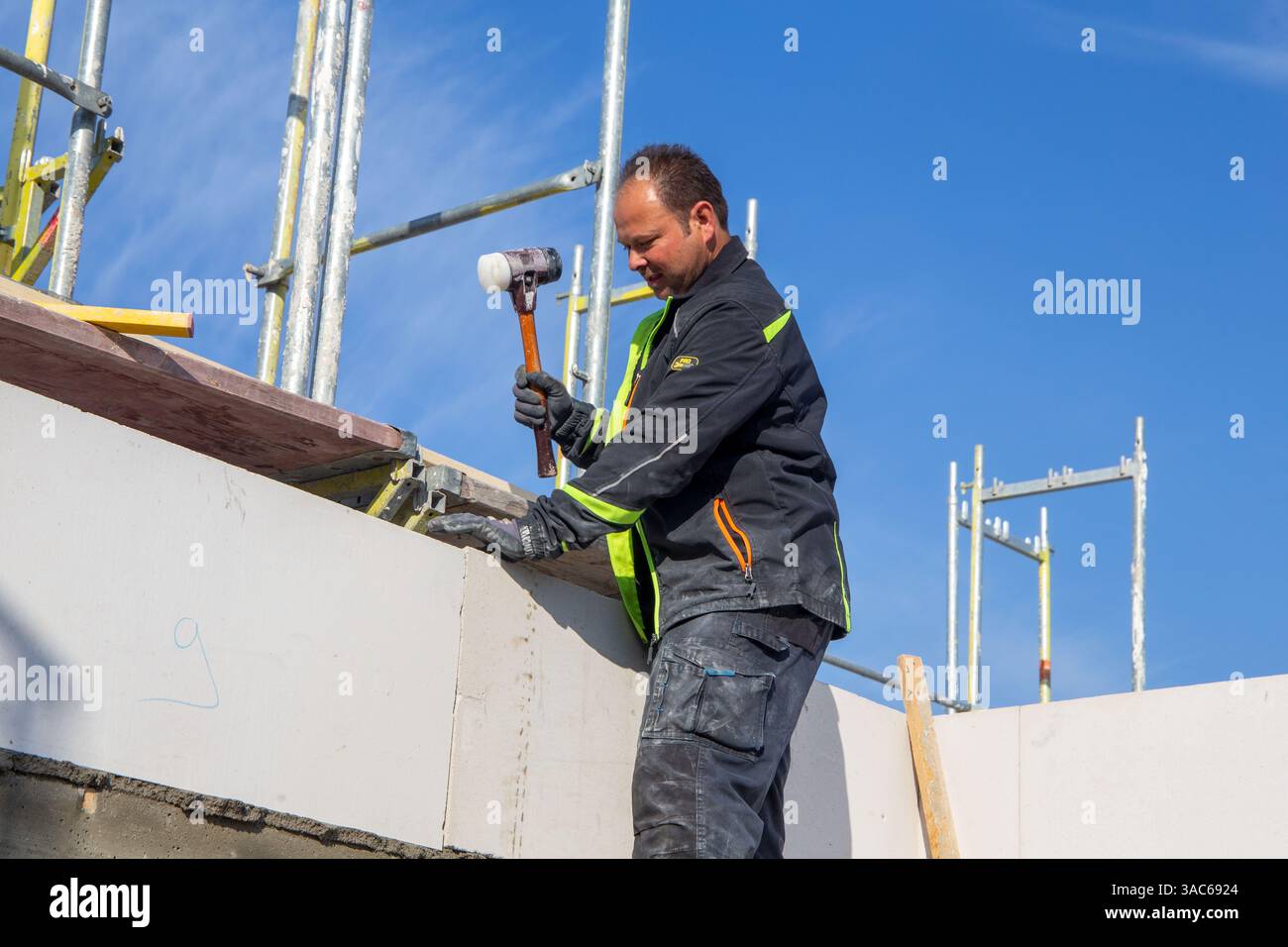 Il muratore lavora su una nuova casa indipendente Foto Stock