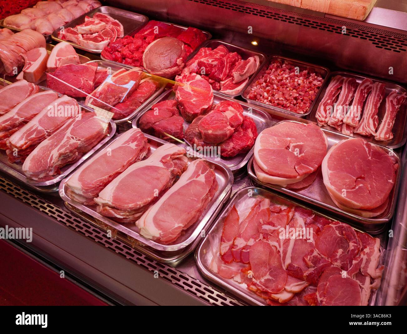 Carne rossa fresca e maiale in una macelleria, Inghilterra, Regno Unito Foto Stock