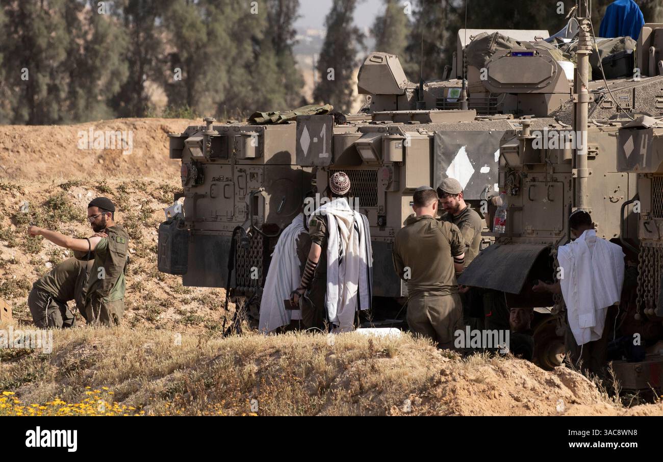 Israele meridionale, Israele. 3 aprile 2025. Il 3 aprile 2025, durante le preghiere mattutine all'interno di Israele meridionale in un'area di sosta lungo il confine meridionale della Striscia di Gaza, gli israeliani saldano al loro vettore di personale corazzato (APC). Israele ha intensificato i combattimenti nel sud della Striscia di Gaza man mano che aumentano le zone di sicurezza all'interno della Striscia di Gaza, nel tentativo di aumentare la pressione su Hamas per liberare gli ostaggi israeliani detenuti dal 7 ottobre 2023. Foto di Jim Hollander/UPI credito: UPI/Alamy Live News Foto Stock