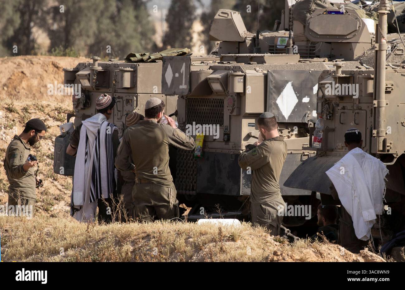 Israele meridionale, Israele. 3 aprile 2025. Il 3 aprile 2025, durante le preghiere mattutine all'interno di Israele meridionale in un'area di sosta lungo il confine meridionale della Striscia di Gaza, gli israeliani saldano al loro vettore di personale corazzato (APC). Israele ha intensificato i combattimenti nel sud della Striscia di Gaza man mano che aumentano le zone di sicurezza all'interno della Striscia di Gaza, nel tentativo di aumentare la pressione su Hamas per liberare gli ostaggi israeliani detenuti dal 7 ottobre 2023. Foto di Jim Hollander/UPI credito: UPI/Alamy Live News Foto Stock