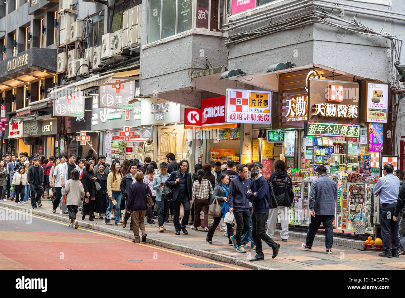 Pedoni in una strada trafficata, Haiphong Road, Tsim Sha Tsui, Kowloon, Hong Kong, Cina Foto Stock