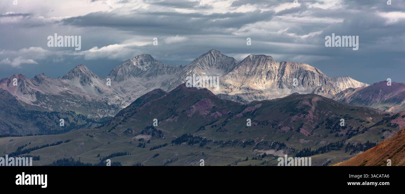 Accentuato dalla luce soffusa di L/R: Siberia Peak, Capitol Peak, Snowmass Mountain e Haggerman Peak. Catturato in una tempesta di tarda estate. Foto Stock