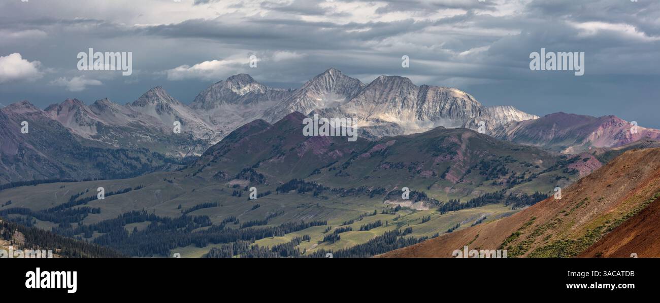 Accentuato dalla luce soffusa di L/R: Siberia Peak, Capitol Peak, Snowmass Mountain e Haggerman Peak. Catturato in una tempesta di tarda estate. Foto Stock