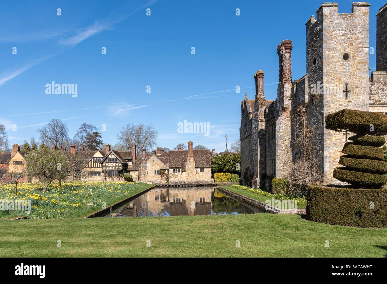 Vista del castello di Hever, del lago e dei giardini in un giorno di primavera soleggiato, Kent, Inghilterra, Regno Unito, con narcisi in fiore Foto Stock