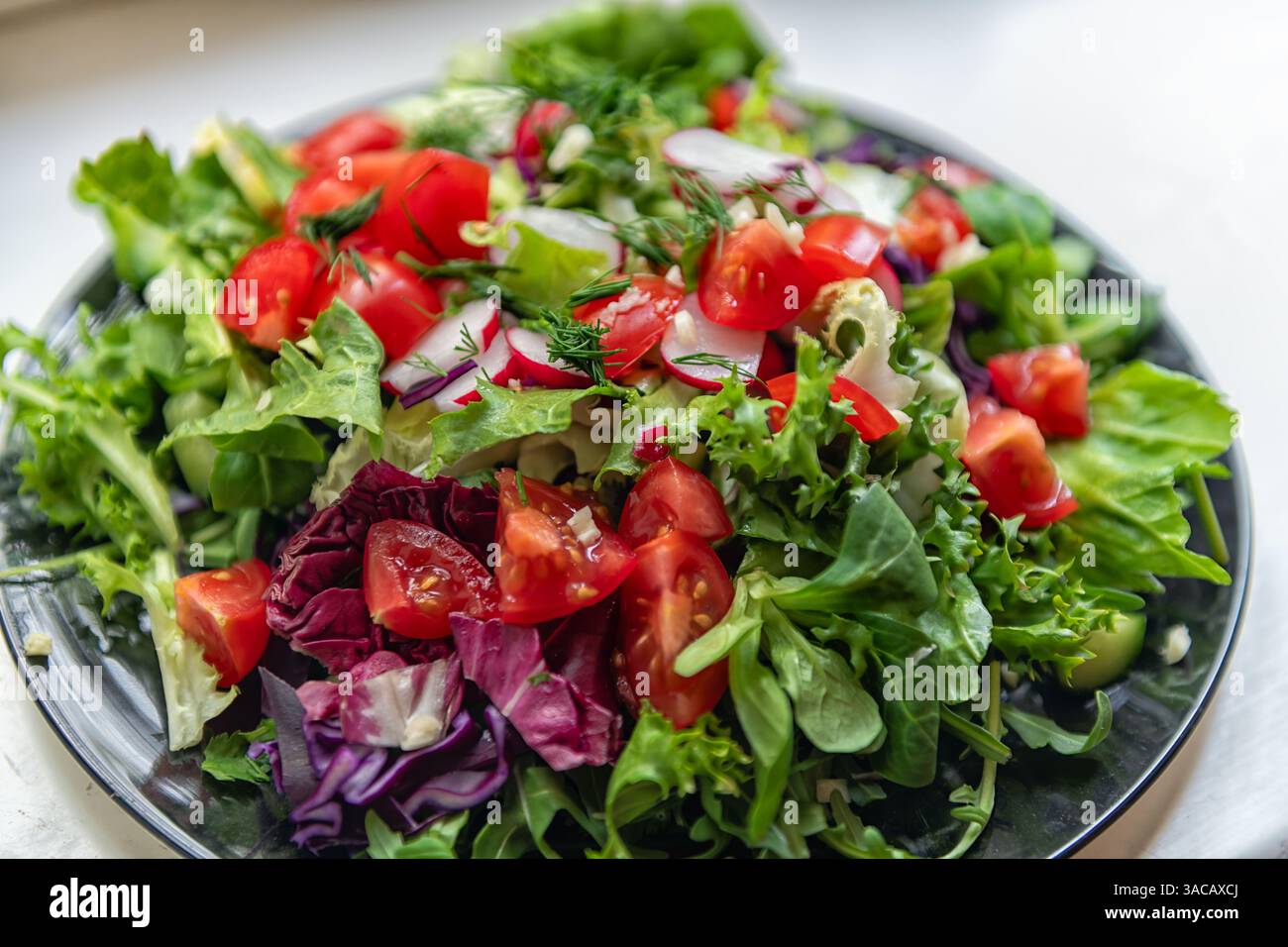 Insalata di verdure fresche crude tritate con lattuga verde, raddicio, cavolo, pomodori e aneto un macro ravvicinato vivace e sano della consistenza Foto Stock