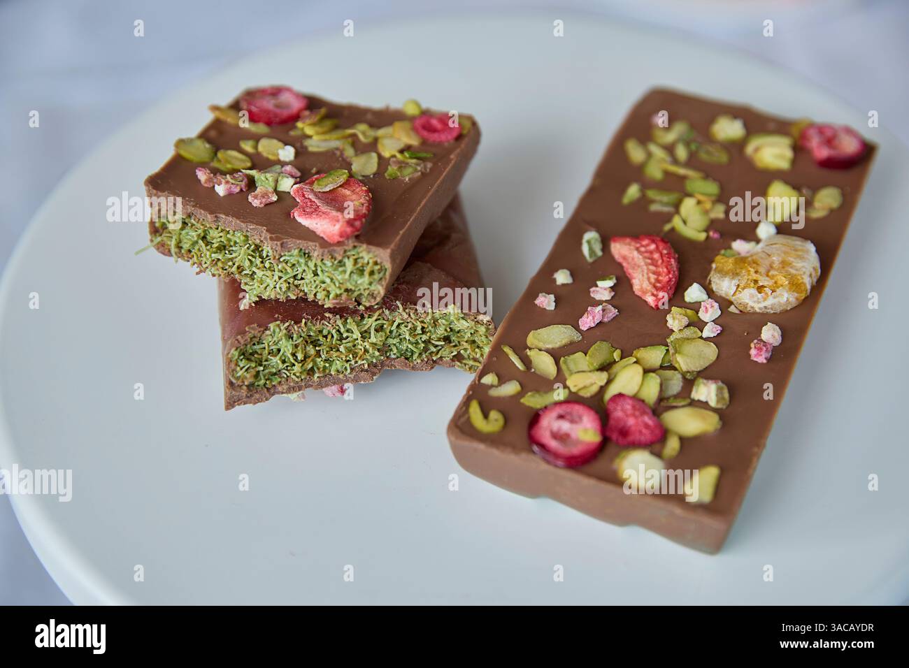 Cioccolato di Dubai. Ricca arte del cioccolato, delizia di dolci prelibatezze, adornata con lampone luminoso e pistacchi vividi, che richiamano con pu Foto Stock