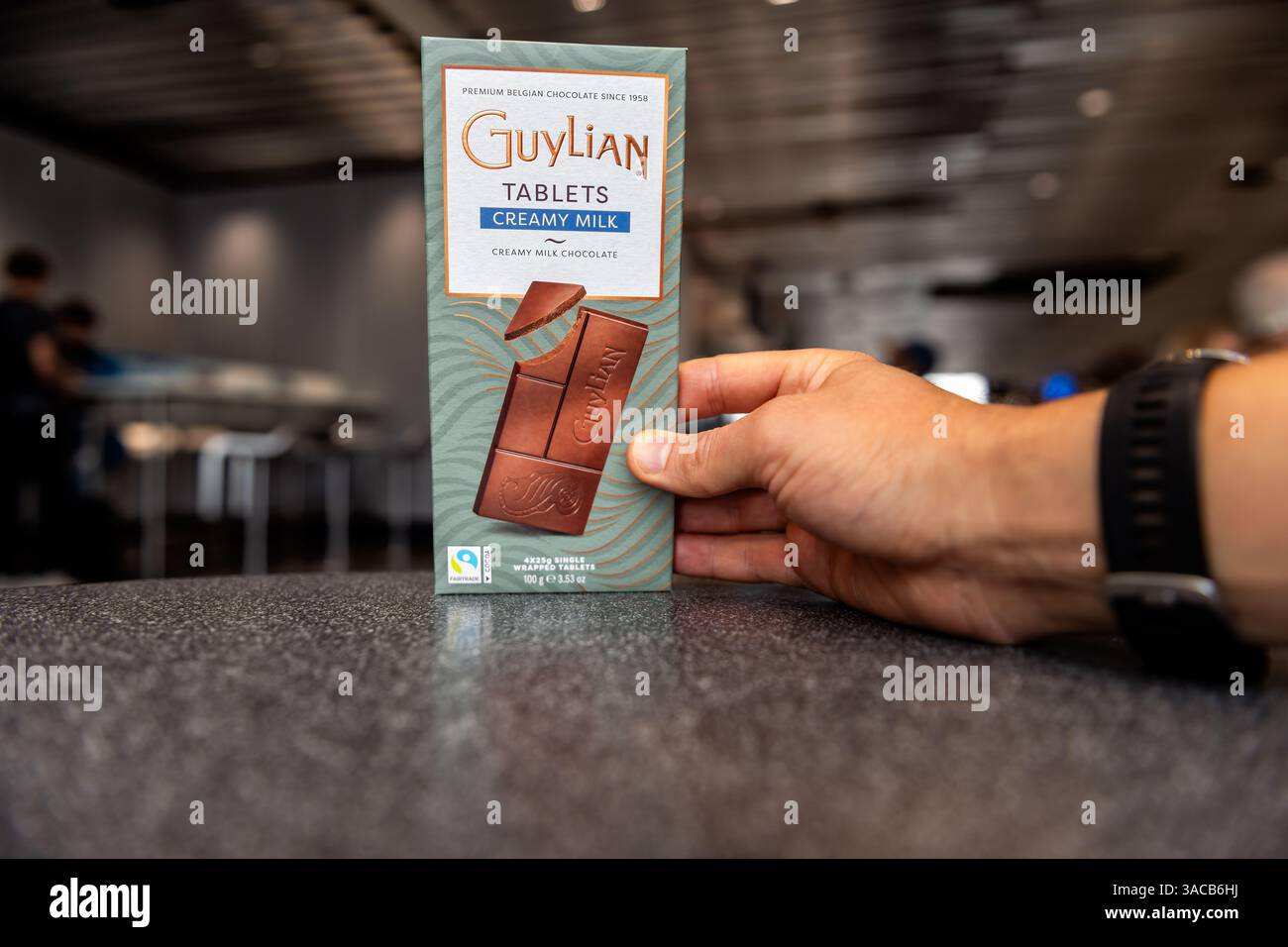 Francoforte, Germania - 28 agosto 2023: Barretta di cioccolato belga al latte guyliano cremoso a mano in mano in aeroporto Foto Stock
